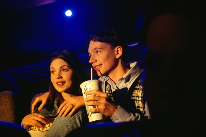 Ilustração: casal come pipoca no escurinho do cinema