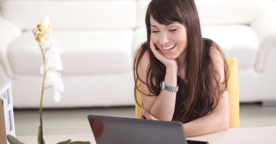 Namoro virtual; amor online; web; notebook;  mulher sorrindo na frente do computador; apaixonada; paixão; à distância; pela internet